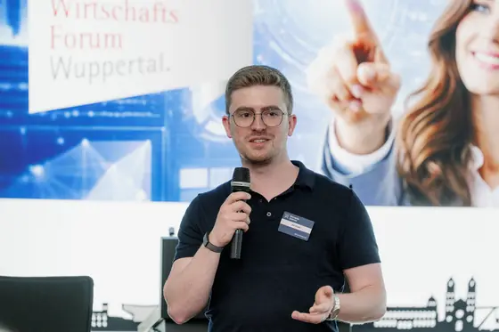 Jan Klues spricht mit Mikrofon auf der Bühne des Wirtschaftsforums Wuppertal